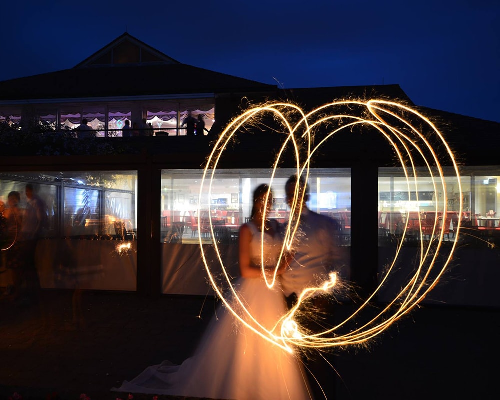 A bride and groom enjoying fireworks at their wedding at the Dudsbury Golf Club, Bournemouth