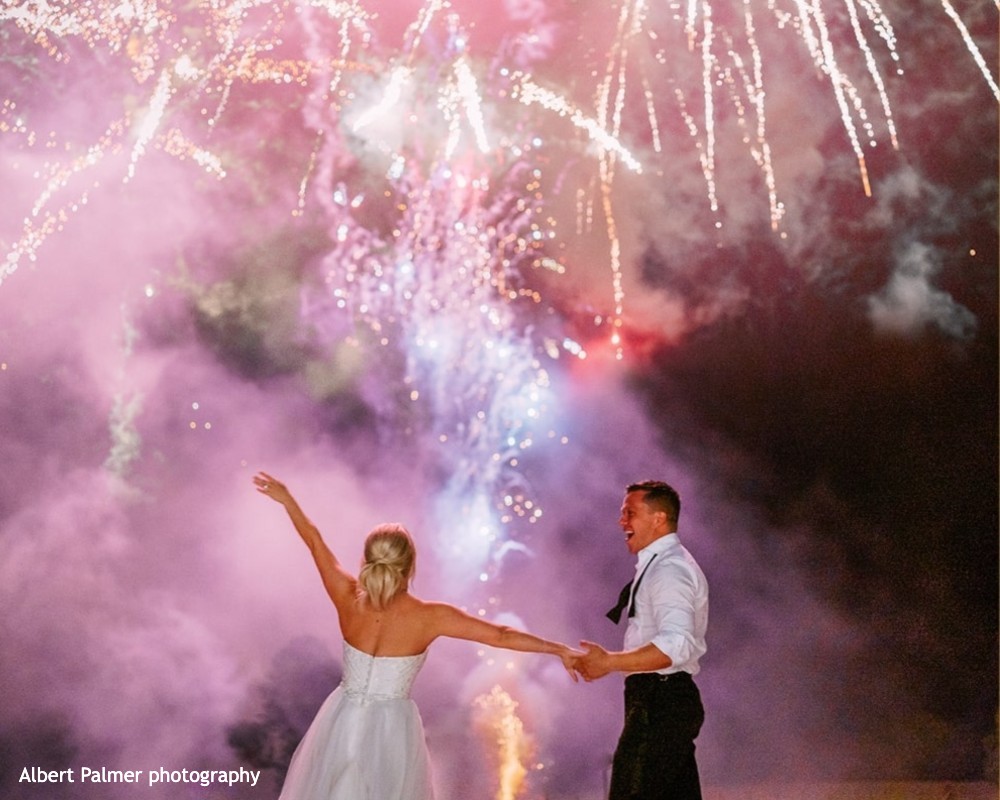 A bride and groom enjoying fireworks at their wedding